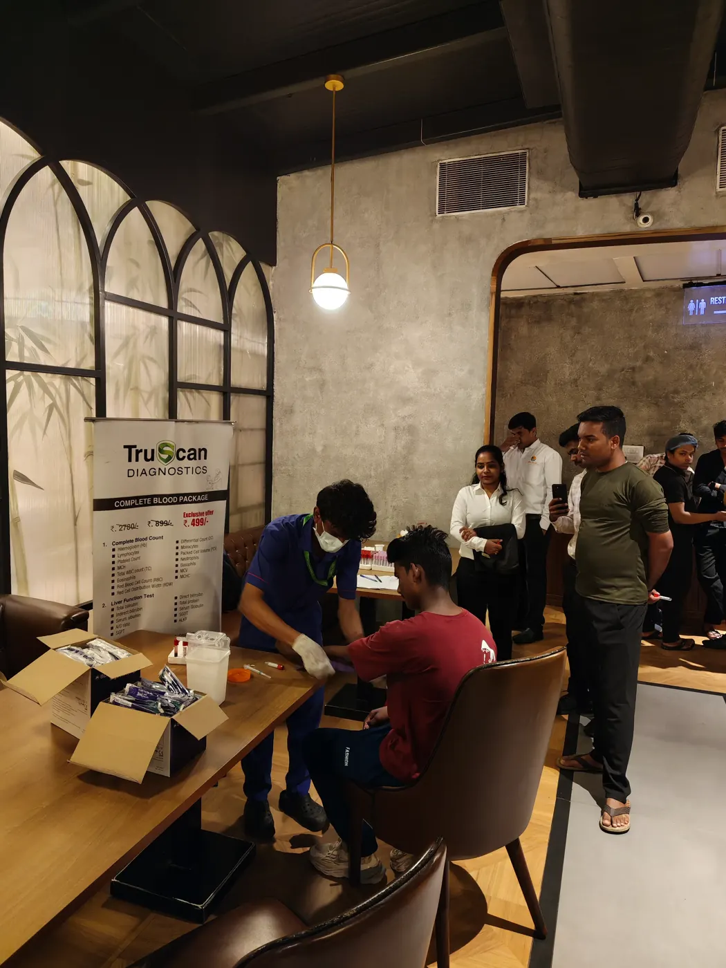TruScan technician drawing blood during a diagnostic health camp